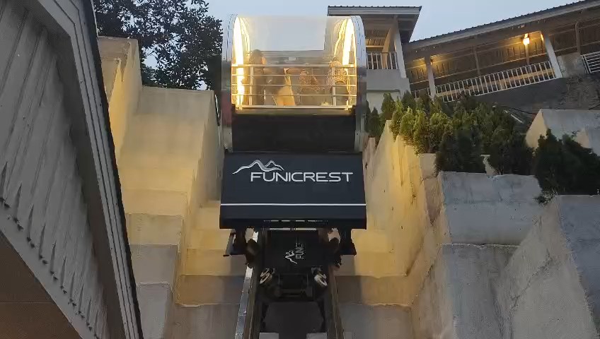 Funicular Rail Car carrying a group of people up a steep incline.